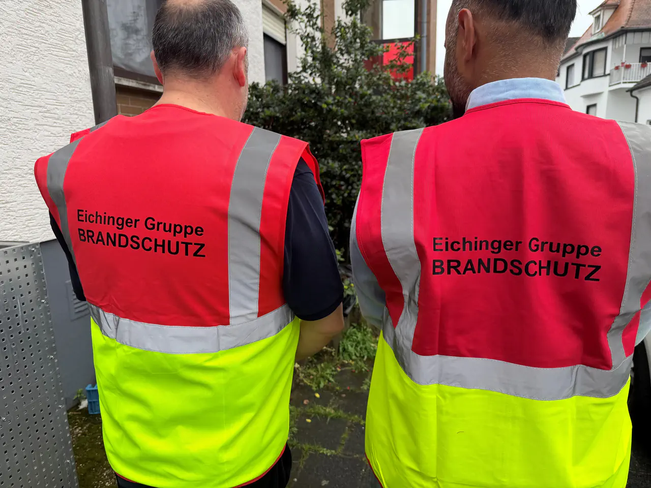 Zwei geschulte Mitarbeiter der Eichinger Sicherheit und Service GmbH mit Brandschutz-Warnwesten für professionelle Brandwachen und Brandschutzposten