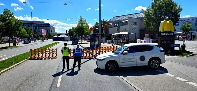 Sicherheitsmitarbeiter der Eichinger Sicherheit und Service GmbH sichern mit Einsatzfahrzeug eine Straßensperre