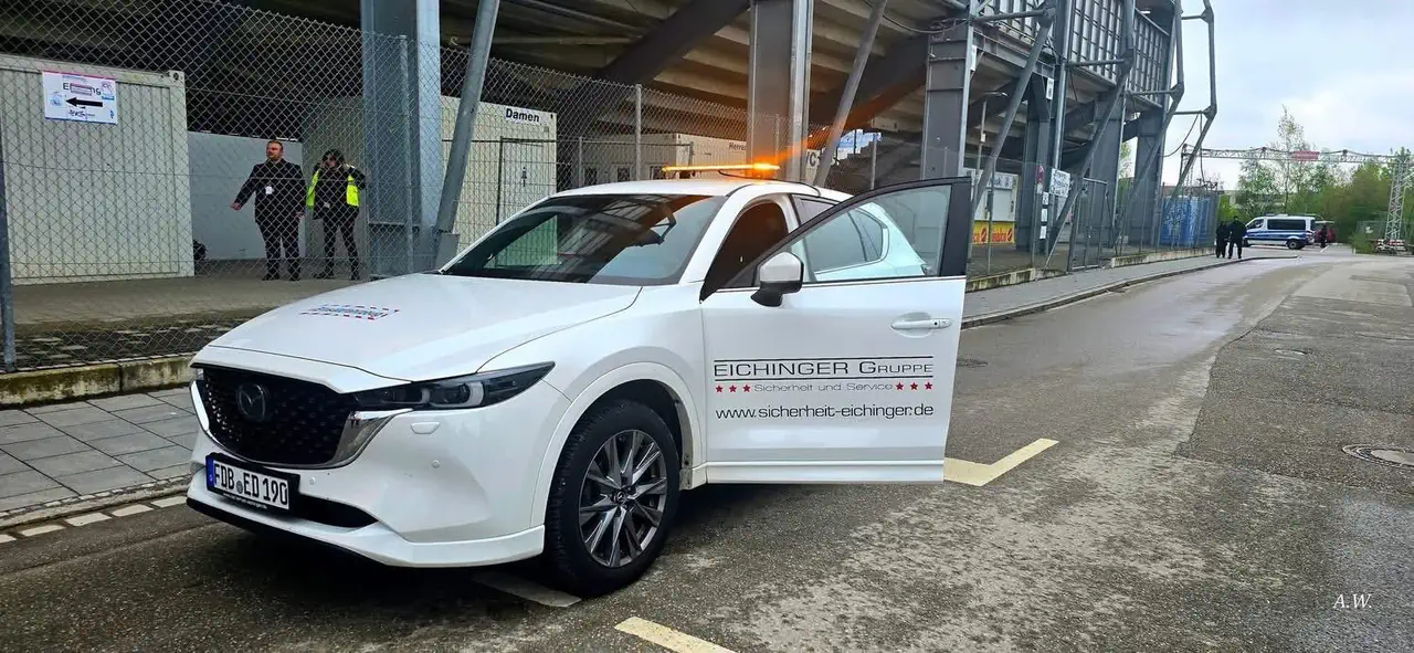 Einsatzfahrzeug der Eichinger Sicherheit und Service GmbH mit Sicherheitsmitarbeitern im Einsatz an einem Stadion
