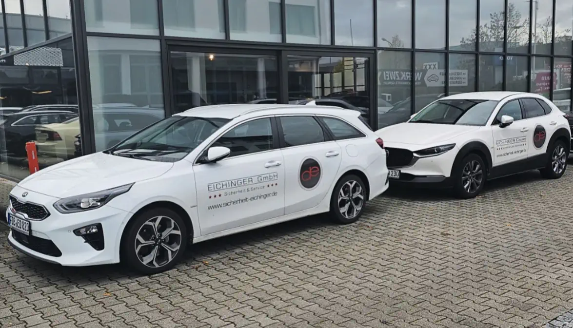 Einsatzfahrzeugflotte der Eichinger Sicherheit und Service GmbH vor einem modernen Firmengebäude für das Parkplatz- und Verkehrsmanagement