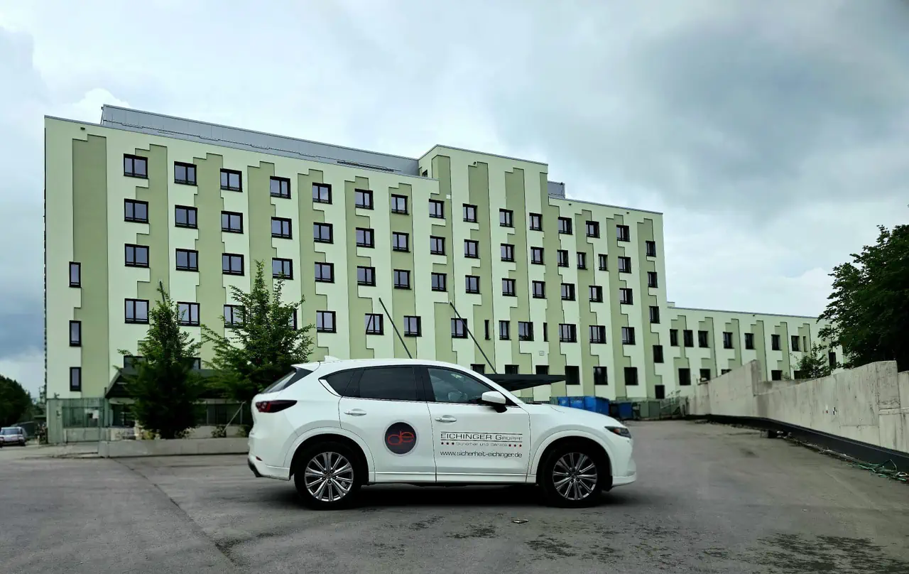 Einsatzfahrzeug der Eichinger Sicherheit und Service GmbH bei der Revierkontrolle vor einem Gebäudekomplex