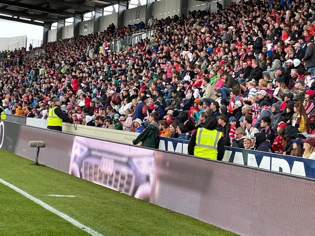 Ordner der Eichinger Sicherheit und Service GmbH sichern den Innenraum eines voll besetzten Fußballstadions
